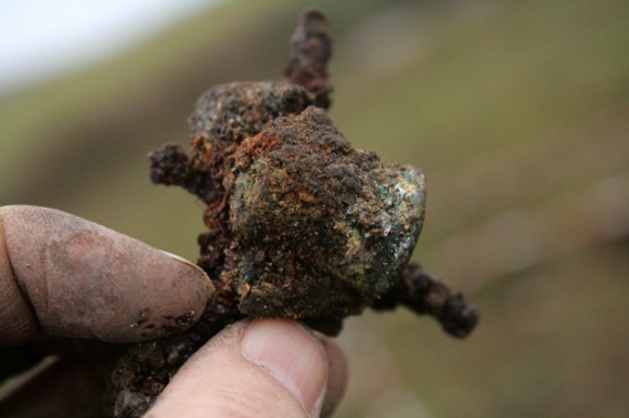Possible copper alloy thimble concreted together with rusty nails