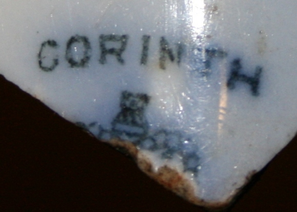 Reverse of blue and white shard bearing 'CORINTH' name over part of a crown design
